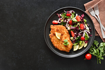 Chicken schnitzel and vegetable salad on plate