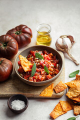 tartare de tomates à l'huile d'olive, ail et sauge avec des chips de tortilla maison au paprika