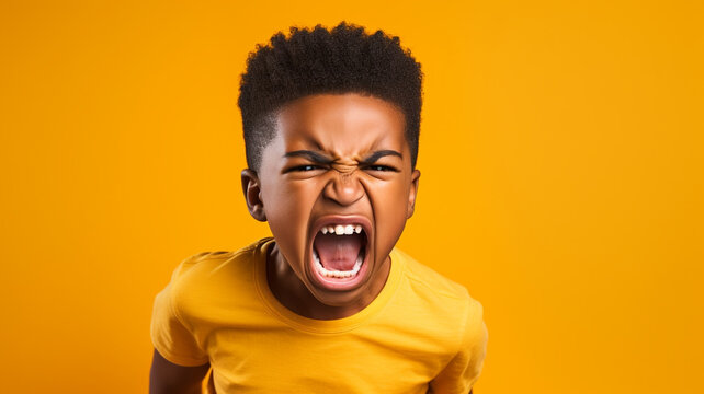 Angry irritated African American boy on yellow background