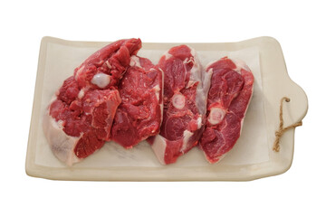 Lamb meat on a ceramic board isolated on white background. Pieces of meat for cooking. Rear part of the meat carcass.