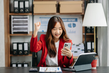 Young beautiful woman using laptop and tablet while sitting at her working place. Concentrated at work..