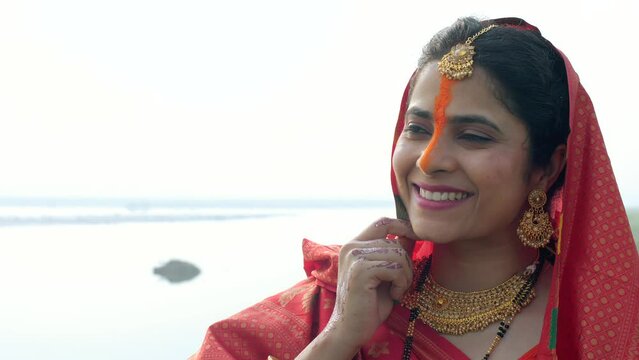 Portrait of a happy Indian woman wearing bright orange sindoor on the occasion of Chhath Puja. An Indian woman wearing traditional attire celebrating Chhath Puja - deep-rooted traditions  worship o...