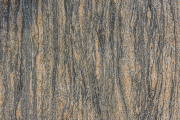 Pattern background of granite stone. Vertical lines from a brown stone surface. Structures become...