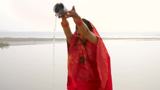Indian women doing the sacred ritual of offering water to the Sun God during the Chhath Puja celebration. Women dressed in vibrant and traditional clothing to celebrate Chhath Puja -Hindu Festival ...