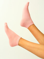 pink socks with copy space on human foot close up photo on white background