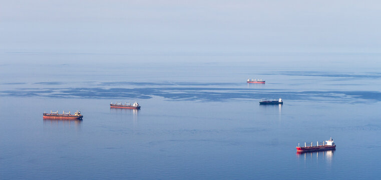 Minimalist picture with just the Mediterranean sea, a blue sky and five cargo boats. Oran, Algeria.