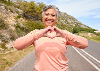 Senior woman, heart hands and runner on road for fitness, love icon and portrait for smile, workout...