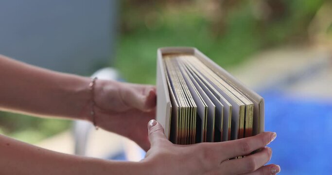the gilded book edges in a captivating slow-motion shot. View the book from above in close-up. Observe the corners and endpapers of the book. Watch as someone flips through its pages. 