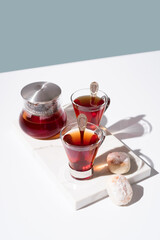 Té rojo con pasteles y dulces sobre mármol	