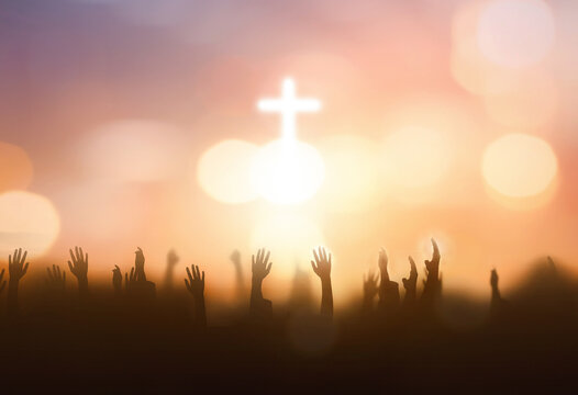 soft focus of Christian worship with raised hand on white cross background