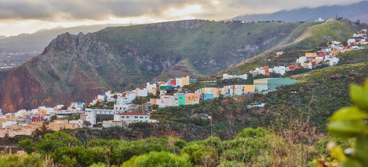 Fototapeta premium Colorful buildings in Santa Cruz, La Palma, Canary Islands with copy space. Beautiful cityscape with bright colors and mountains. A vibrant holiday, vacation and getaway destination on the hillside