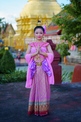 Fototapeta na wymiar Pretty Asian women wearing beautiful Thai traditional dress in Hundred Thousand Lantern Festival or Yi Peng Festival for worship at Phra That Hariphunchai temple in Lamphun, Thailand.