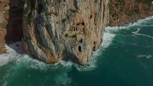 Porto Flavia: fantastic aerial shot of the old mining port on the island of Sardinia and the waves hitting the cliff.