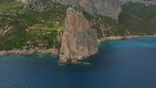 aerial view in orbit over the Monolite di Pedra Longa on the island of Sardinia on a sunny day with beautiful colors.