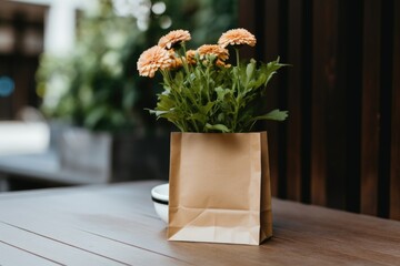 A paper bag is on the table with a bouquet of flowers