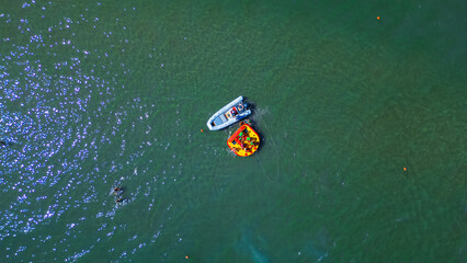 A boat takes tourists out to sea. Italian famous seaside resort as seen from a drone. Summer...