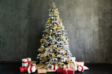 Decorated Christmas tree with gifts in white room interior