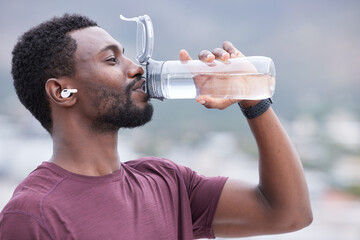 Fitness, drinking water and black man in outdoor nature for exercise, training and running with...