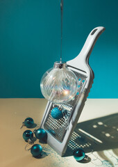 Creative arrangement with food grater and Christmas baubles