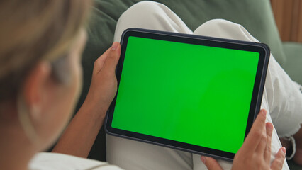 Girl click green screen. Hand hold horizontal ipad close up. Finger tap center tablet. View web...