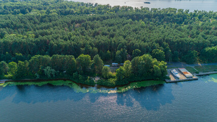 Fototapeta premium Aerial view summer forest and river in sunny day. Drone shot beautiful nature landscape, green trees