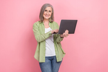 Photo of retired coder woman try understand learning prompts ai generations content maker using laptop isolated on pink color background