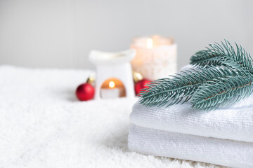 Fresh white towels with fir branch, candles and Christmas decorations. Wellness and wellbeing. SPA...