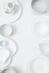 Set of different pure white dishes for home or restaurant on white background. Top view, flat lay, copy space