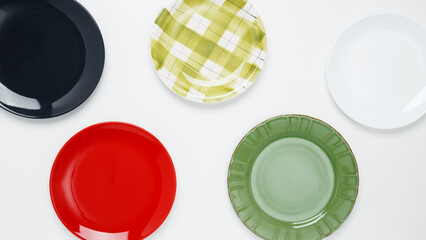 Multicolored dinner plates on a white background. Top view, copy space, flat lay - Powered by Adobe