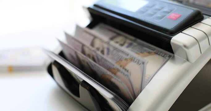 Bill counter device counts money in light bank office. Process of checking dollar bills for authenticity. Bank service in global companies slow motion