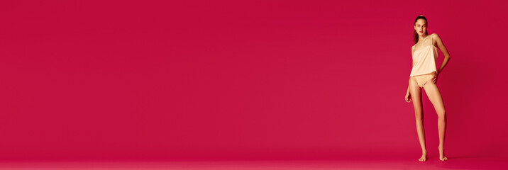 Banner. Girl dressed in underwear and pajama with ponytail hairstyle posing lying on floor and looking at camera. Cheerful woman enjoy morning.