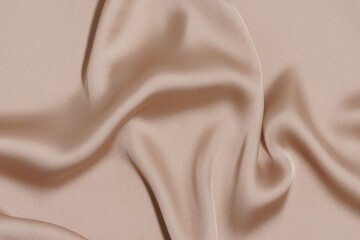 texture crumpled and wrinkled beige polyester or synthetic fabric close-up. background for your design. material for sewing clothes