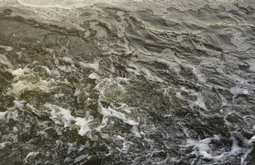 Waves of water of the river and the sea meet each other during high tide and low tide. Deep blue stormy sea water surface with white foam and waves pattern, background photo texture