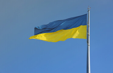 Ukrainian flag isolated on the blue sky with clipping path. Close up waving banner of Ukraine. Tall flag symbol of Ukraine, european country of freedom