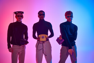 three multiethnic men in black outfits with landline phones surrounded by neon lights, fashion
