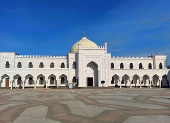 Fototapeta na wymiar Square,white palace with dome and crescent, blue sky.