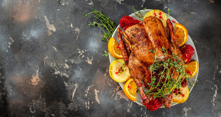 Traditional roasted stuffed Christmas Peking duck with herbs on a dark background. top view. copy space for text