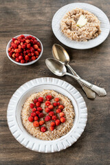 Spelled porridge for breakfast. Wheat porridge with strawberries. Seasonal summer wild berry. Healthy food.	