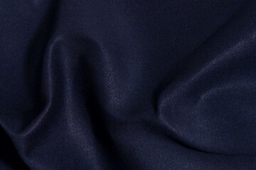 Texture of crumpled dense blue denim close-up. Mockup for your design. Material for making jeans