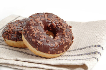 Chocolate donuts on a tablecloth