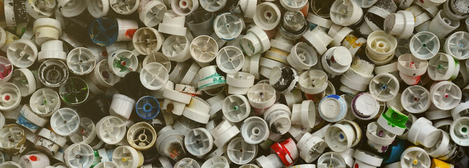 A large number of caps from cans of aerosol paint for graffiti. Smeared with colored paint nozzles...