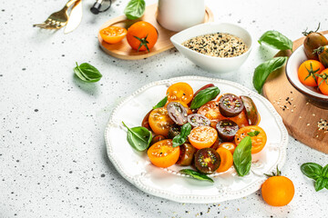 Ripe fresh colorful tomatoes salad with olive oil and basil leaves. clean eating for weight loss. copy space, top view