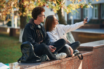 Taking a selfie. Two young students are together outdoors