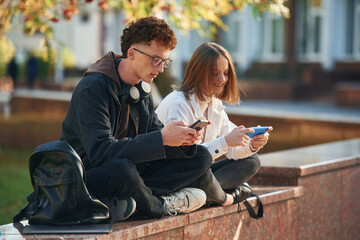 Two young students are together outdoors