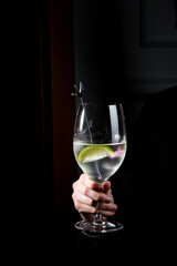 side view of transparent cocktail with ice on a dark background