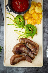 top view of meat ribs with avocado, chips and ketchup on a white plate