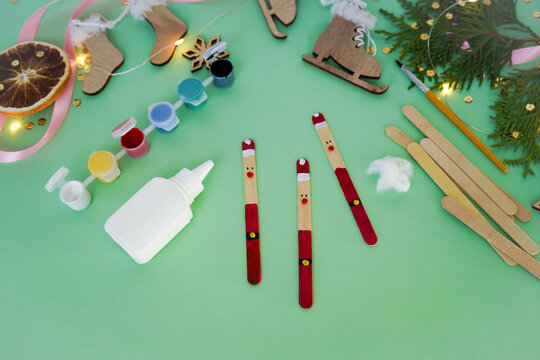 Step by step instruction how to make christmas toy from ice cream sticks. Step 4 with the help of plasticine balls, we make a nose, eyes and a Santa Claus belt. Children's New year handmade craft