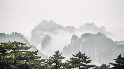 Crédence de cuisine en verre imprimé Monts Huang Dramatic landscape of foggy mountains in the distance: Huangshan National park China