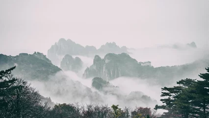 Crédence de cuisine en verre imprimé Monts Huang Dramatic landscape of foggy mountains in the distance: Huangshan National park China