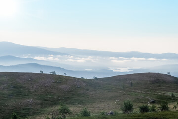 Early in the morning up in the mountains of T&auml;nndalen in Sweden. A beautiful blue sky and morning mist still lingering down in the valley.